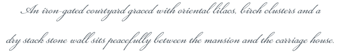 An iron-gated courtyard graced with lilacs, birch clusters and a dry stack stone wall sits peacefully between the mansion and the carriage house.